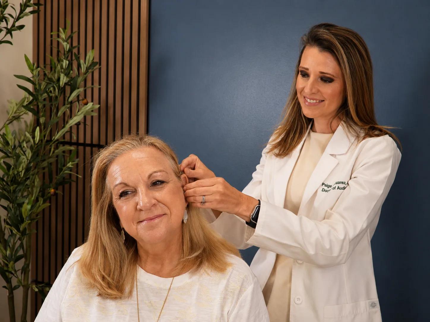 Dr. Paige Juarez checking patient's hearing aid