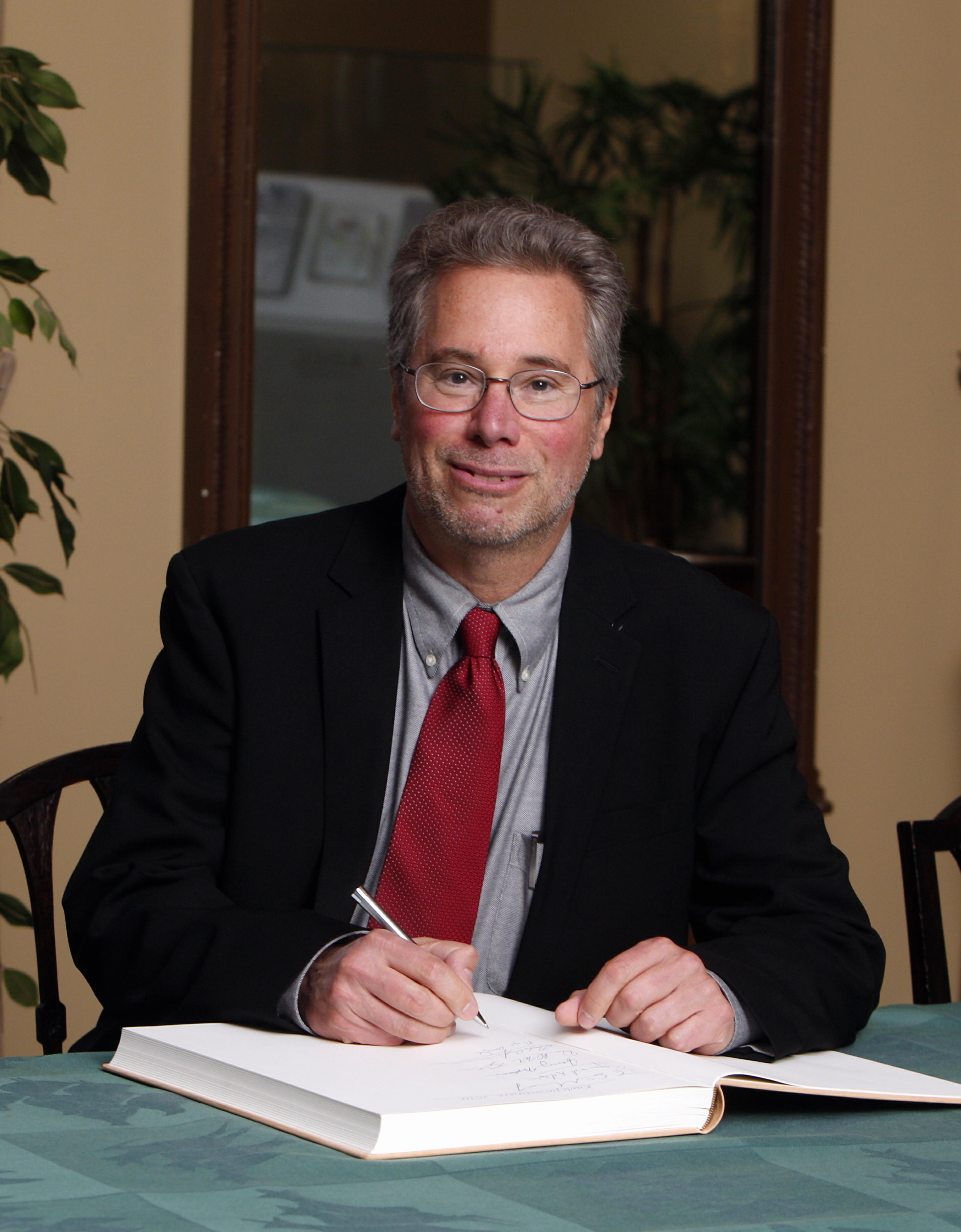 Richard H. Scheller signing the guest book