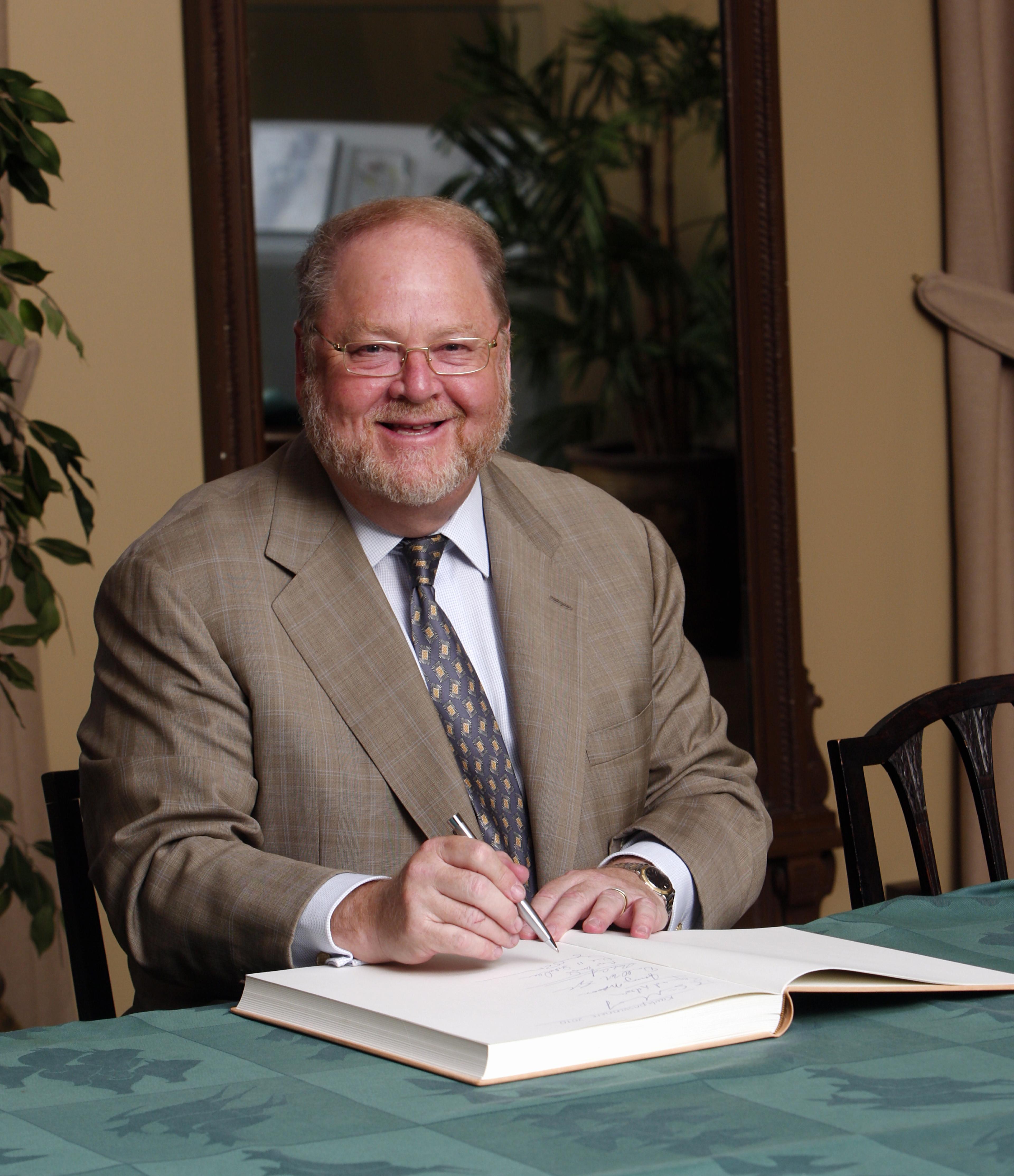 James E. Rothman signing the guest book 