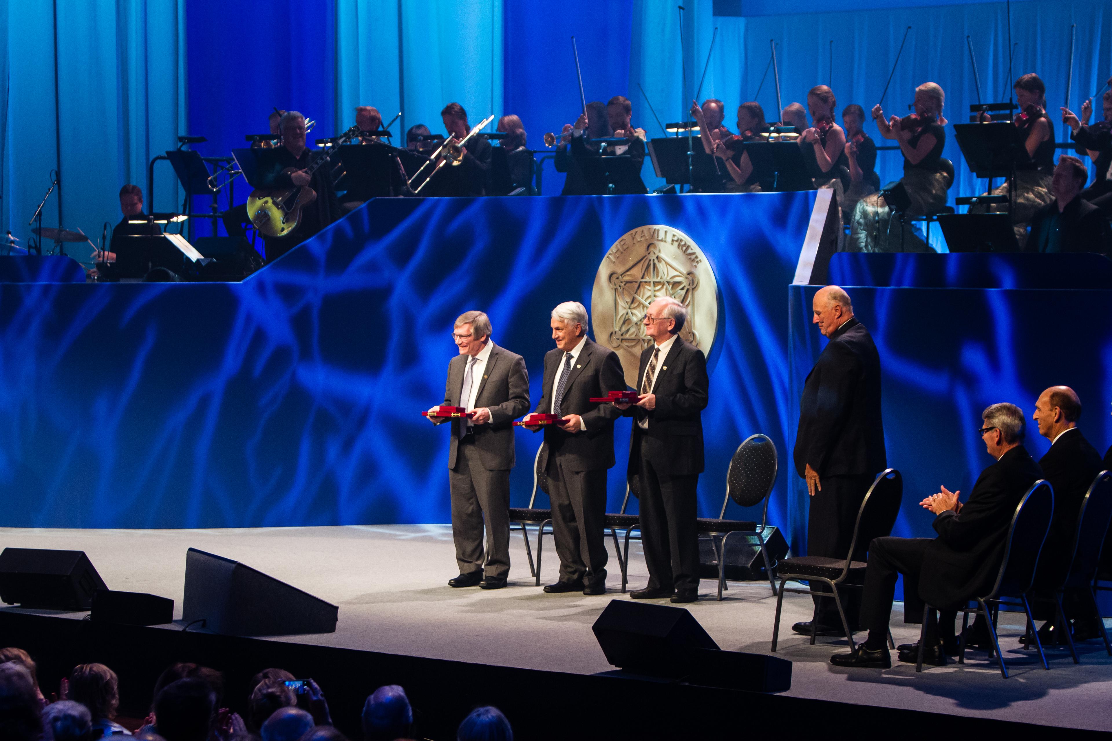 All the three 2014 astrophysics Kavli Prize laureates on stage at the prize ceremony in Oslo together with His Royal Highness King Harald 