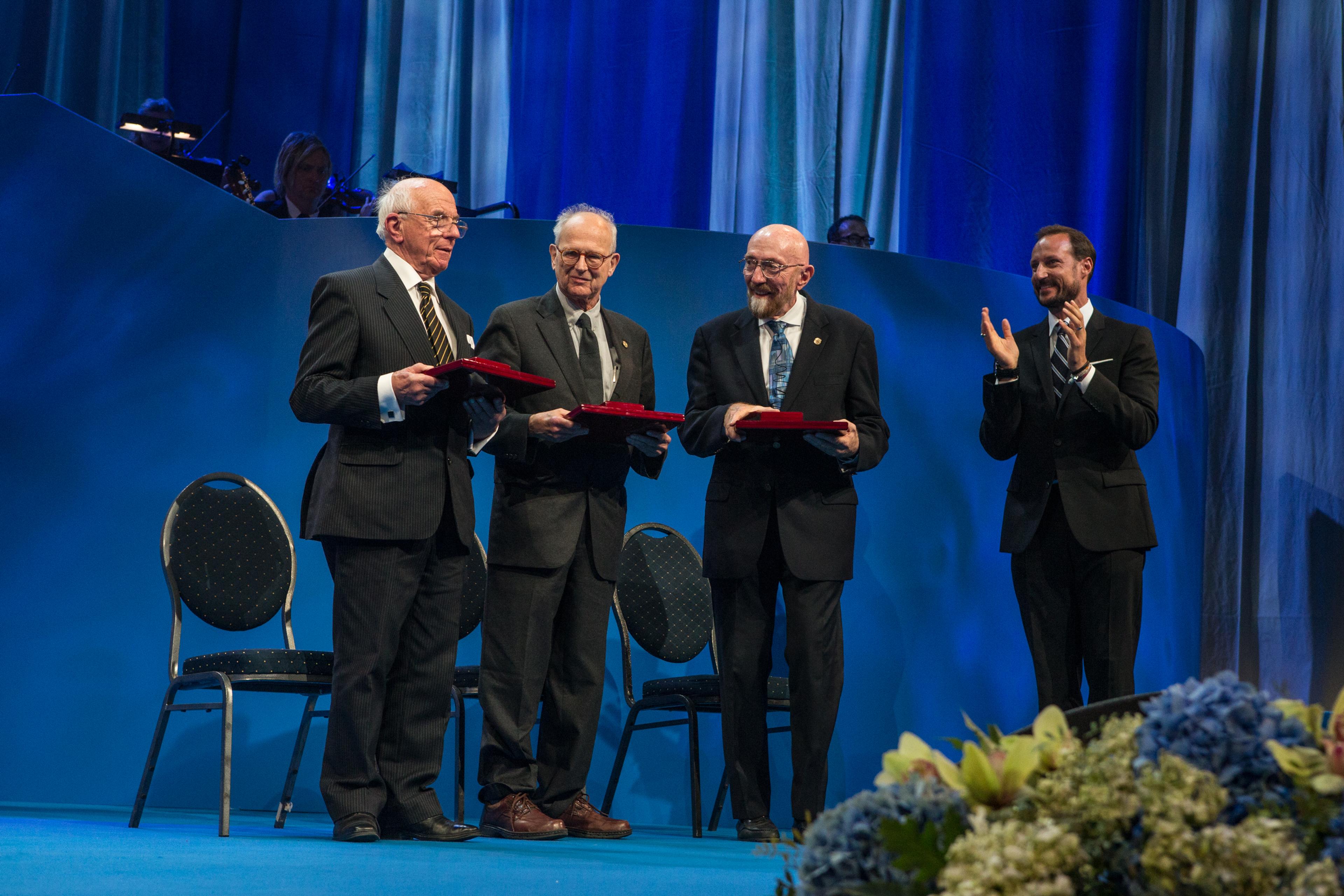 The three astrophysics laureates on stage at the ceremony in Oslo with their awards; from left: Ronald W.P. Drever's representative, Rainer Weiss, Kip S. Thorne and His Royal Highness Crown Prince Haakon 