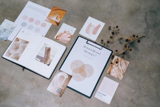 Flat lay tài liệu chiến lược thương hiệu với moodboard và bảng màu