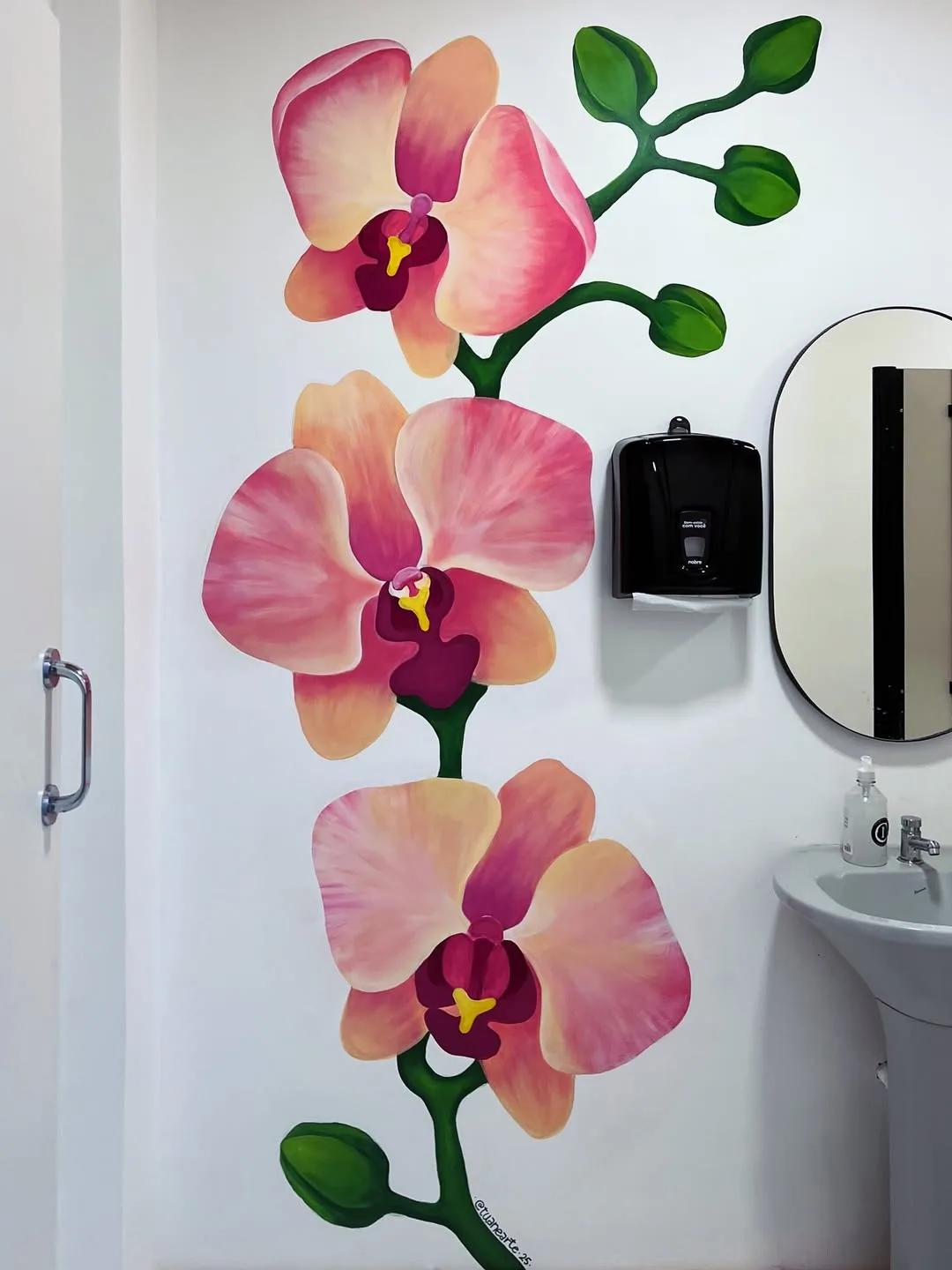 Mural de orquídeas em parede de banheiro de espaço comercial, por Tuane Arte