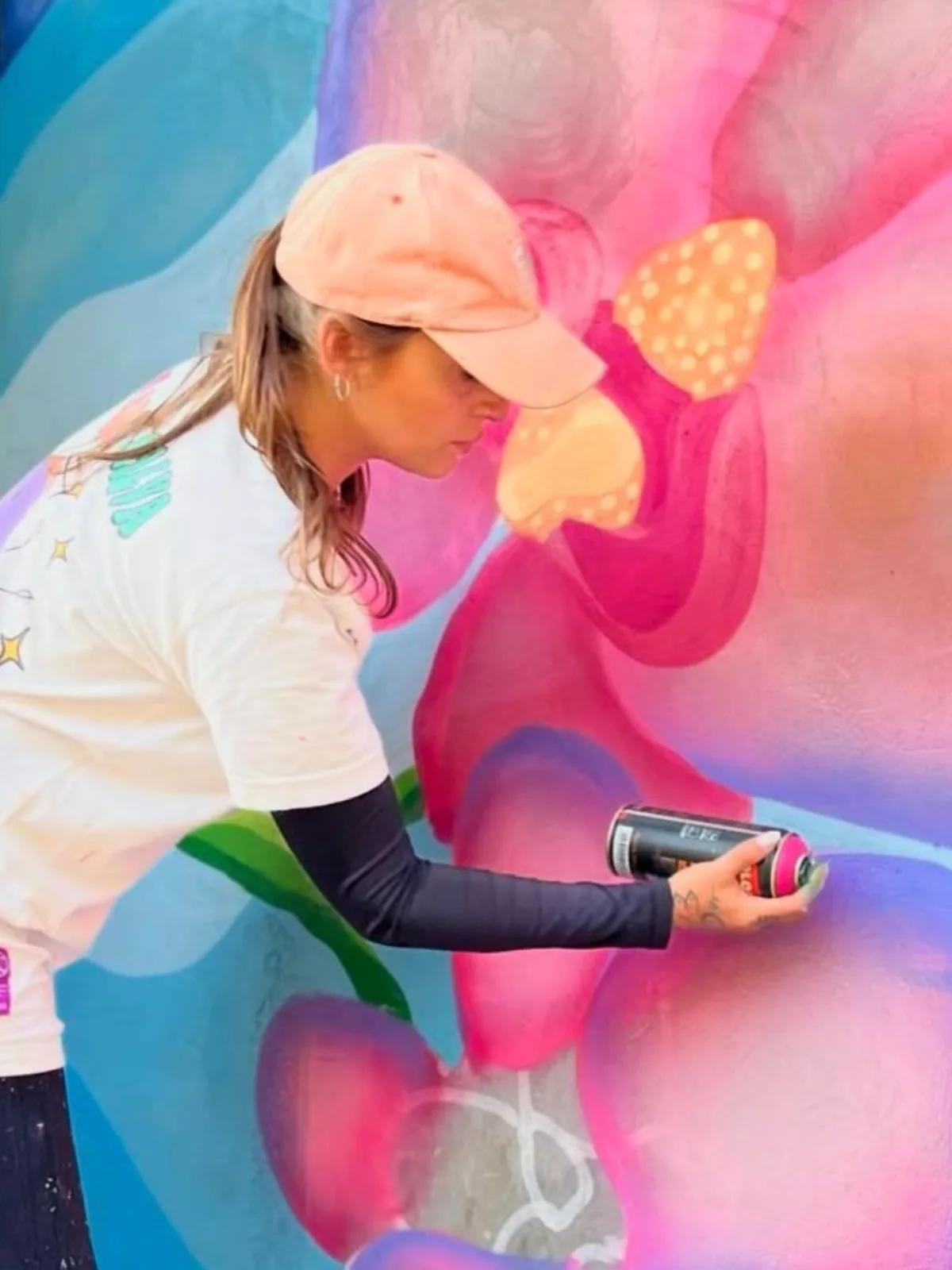 Tuane Arte pintando mural floral com spray
