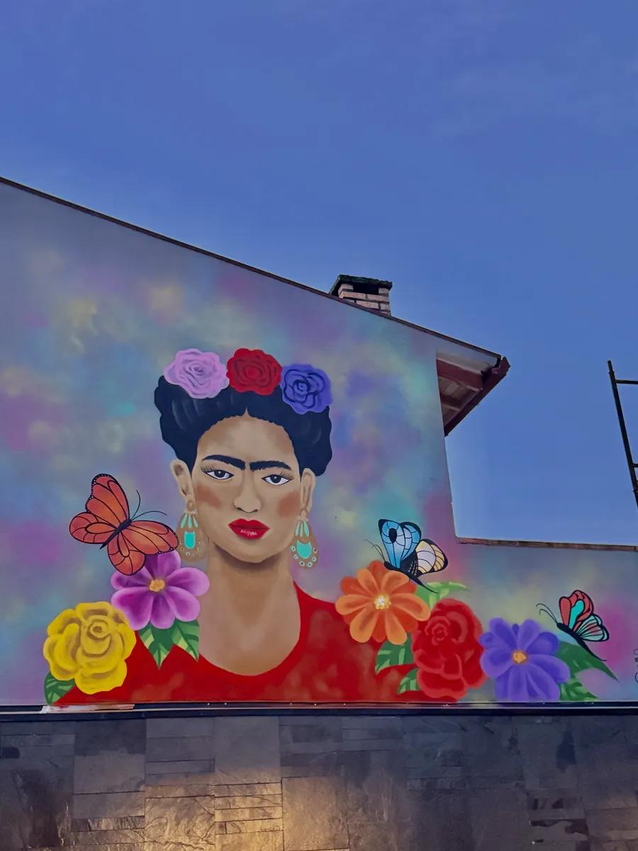 Mural de Frida Kahlo entre flores e borboletas em fachada residencial no Rio Vermelho, Florianópolis, por Tuane Arte