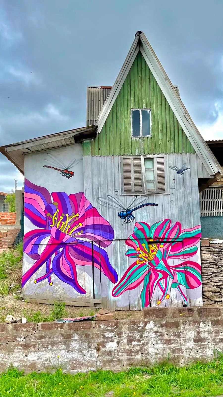 Mural de flores e libélulas em fachada de casa de madeira, por Tuane Arte