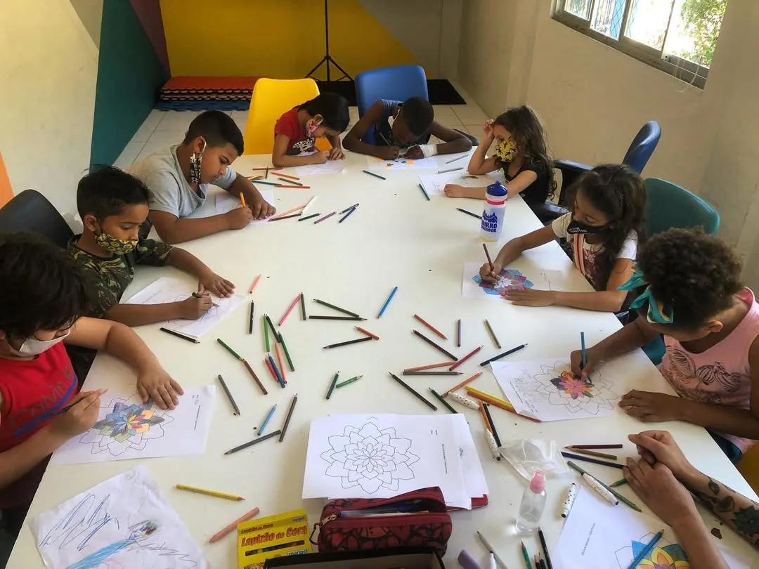 Crianças desenhando mandalas com lápis de cor