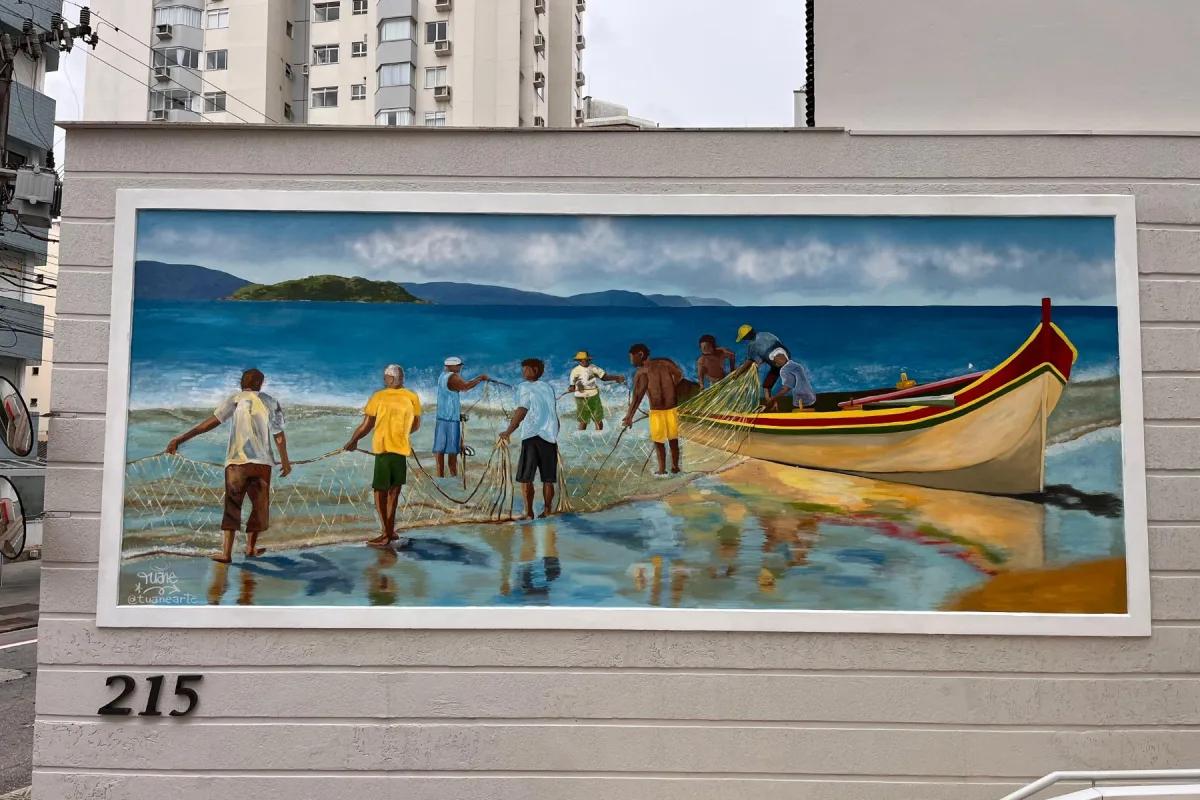 Mural com cena praiana e pescadores na entrada de edifício