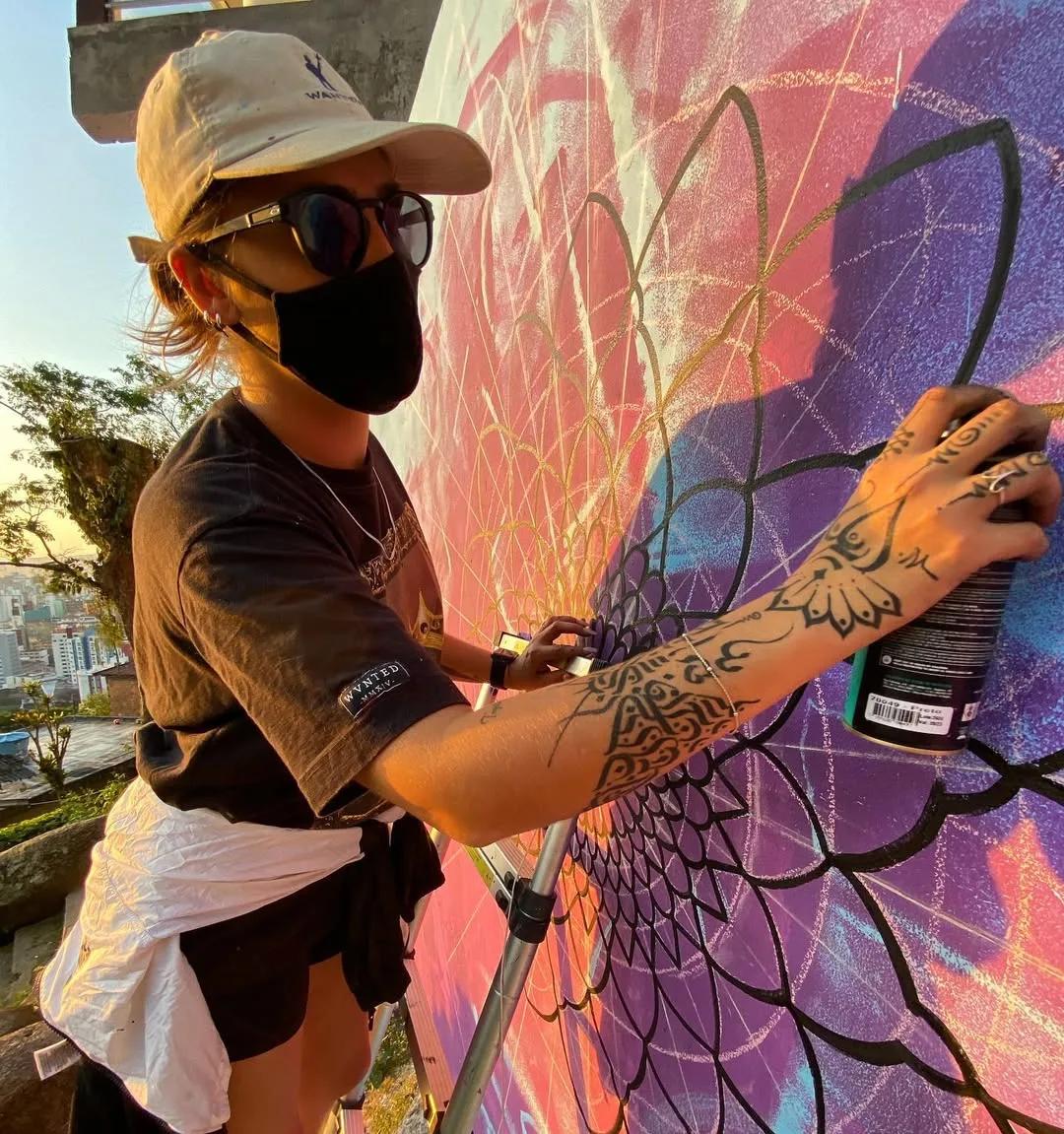 Tuane Arte pintando detalhe de mandala com spray
