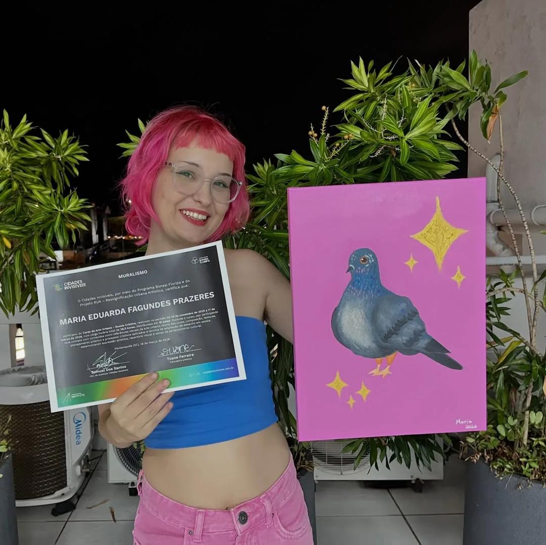 Aluna com certificado do curso de muralismo