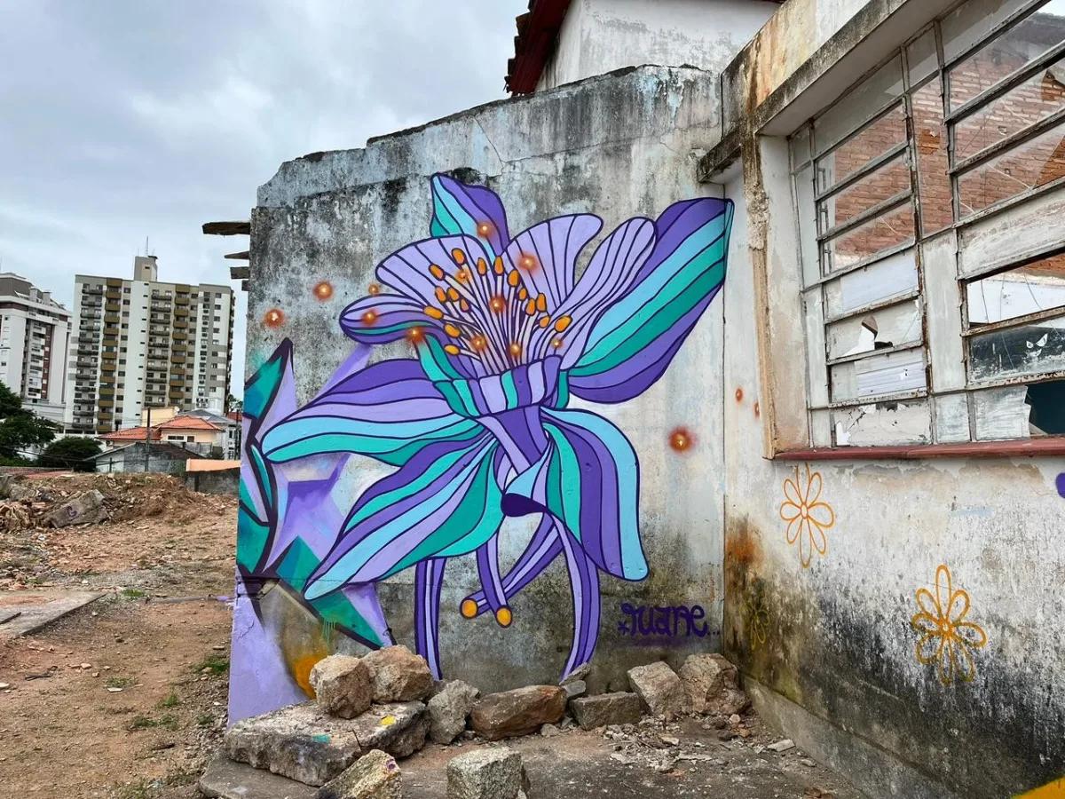 Graffiti com flor azul em muro externo