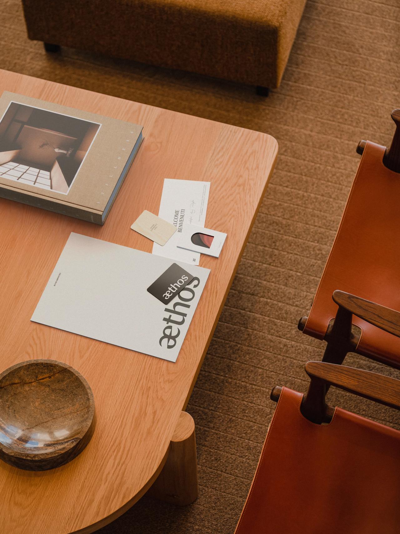 Aethos - Print Collateral in situ on a wooden table