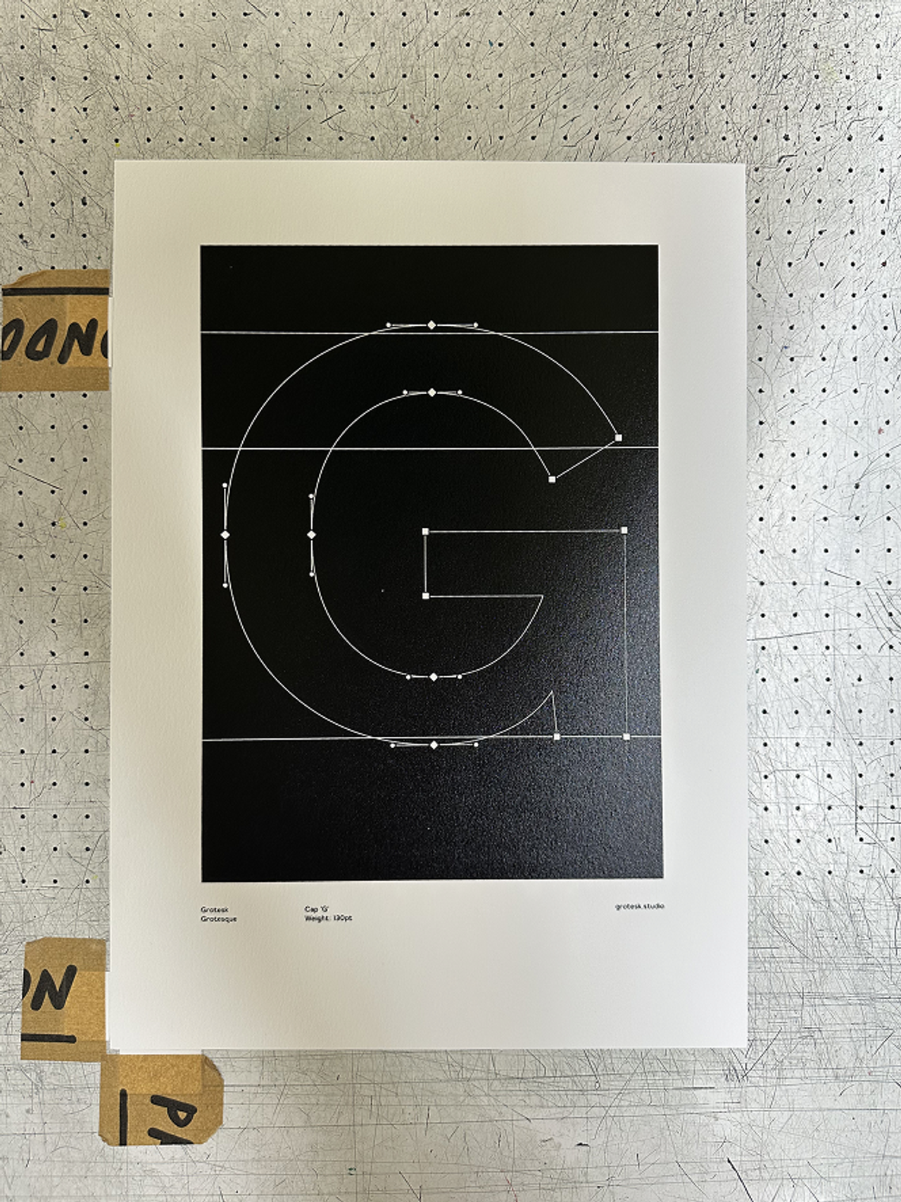Screen-printed G poster pinned to a pegboard