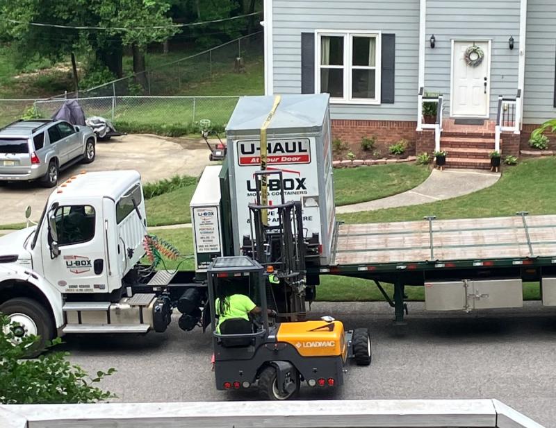 fork lift putting shipping container on large truck