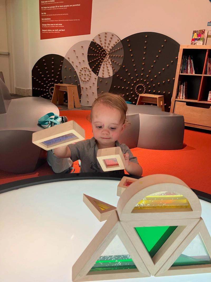 toddler playing with colorful shape blocks