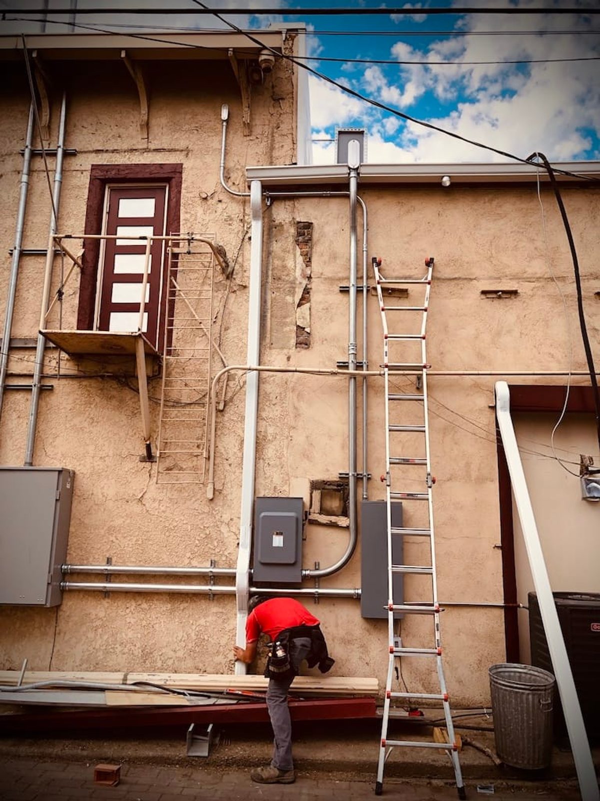 Idaho Seamless Gutter technician repairing gutters on an older downtown building