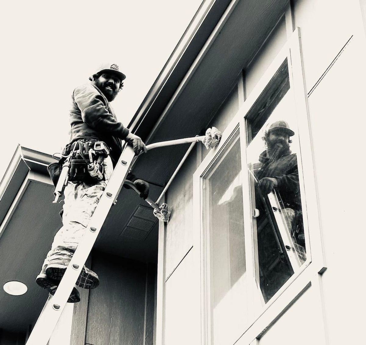 Idaho Seamless Gutter technician cleaning a gutter from a ladder