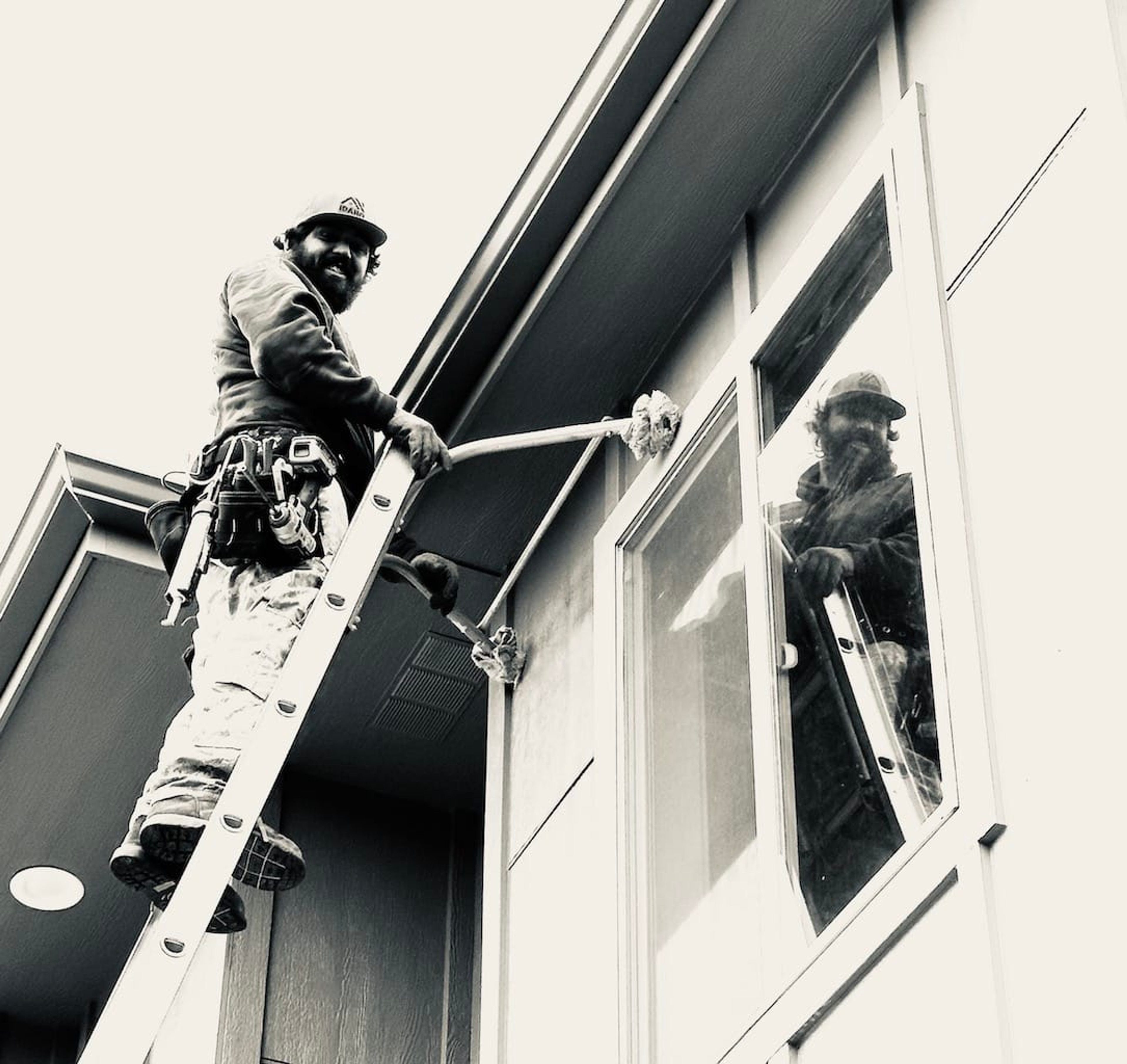Idaho Seamless Gutter technician cleaning a gutter from a ladder