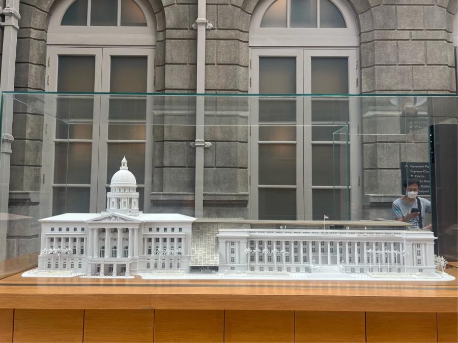 White architectural scale model of the former Supreme Court and City Hall buildings displayed in a glass case at the National Gallery Singapore