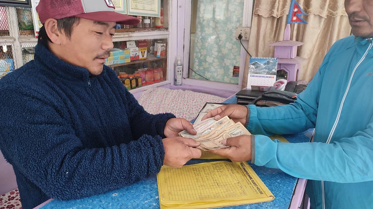 A trekking guide pays the food bill at a teahouse during the Annapurna Base Camp trek.