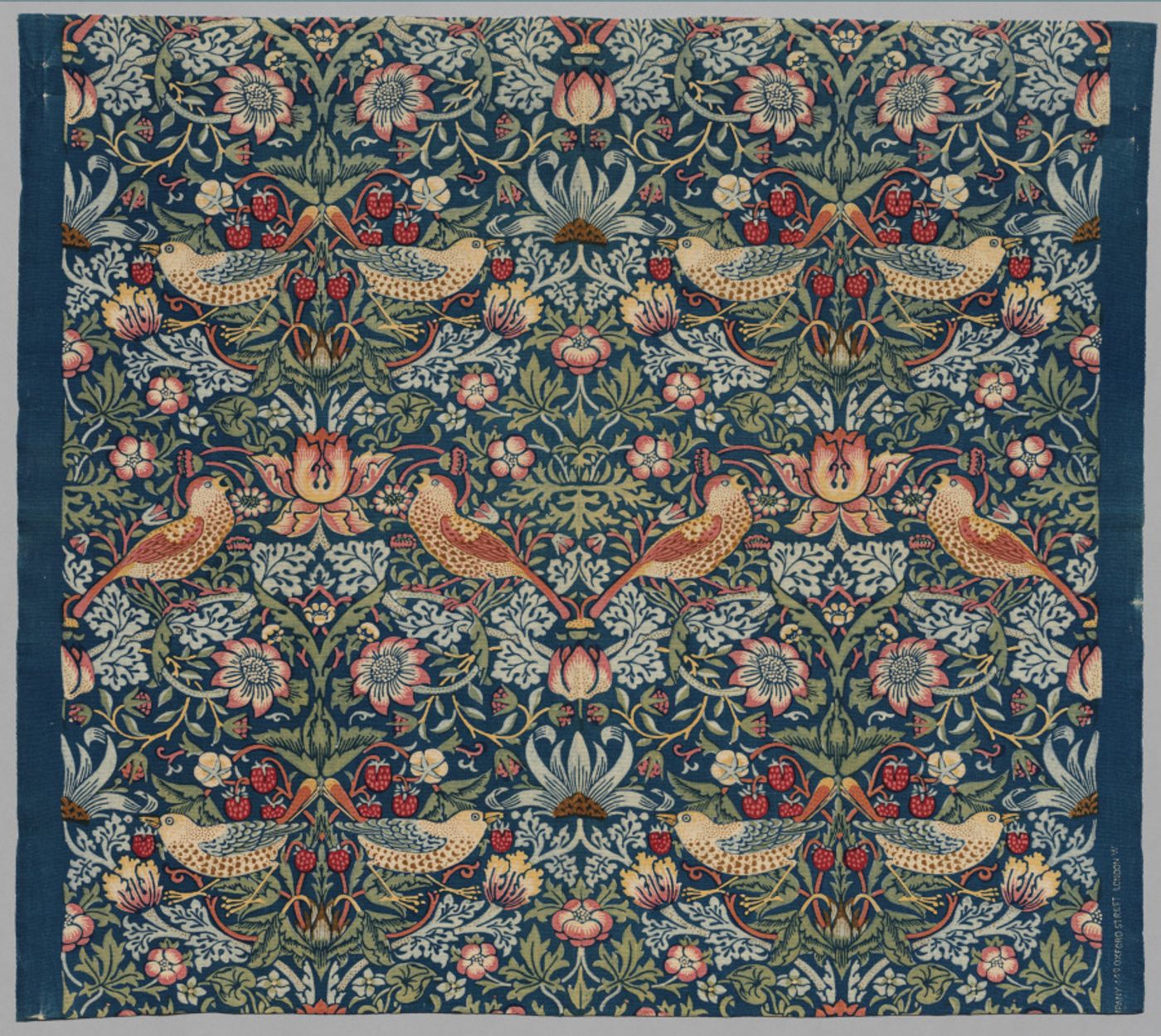 William Morris Strawberry Thief floral textile with birds and flowers on a dark blue ground
