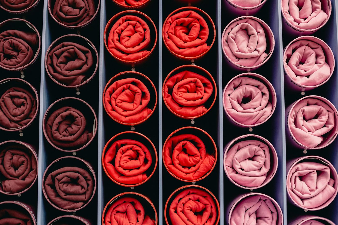 Rolled fabric swatches in shades of brown, red and pink