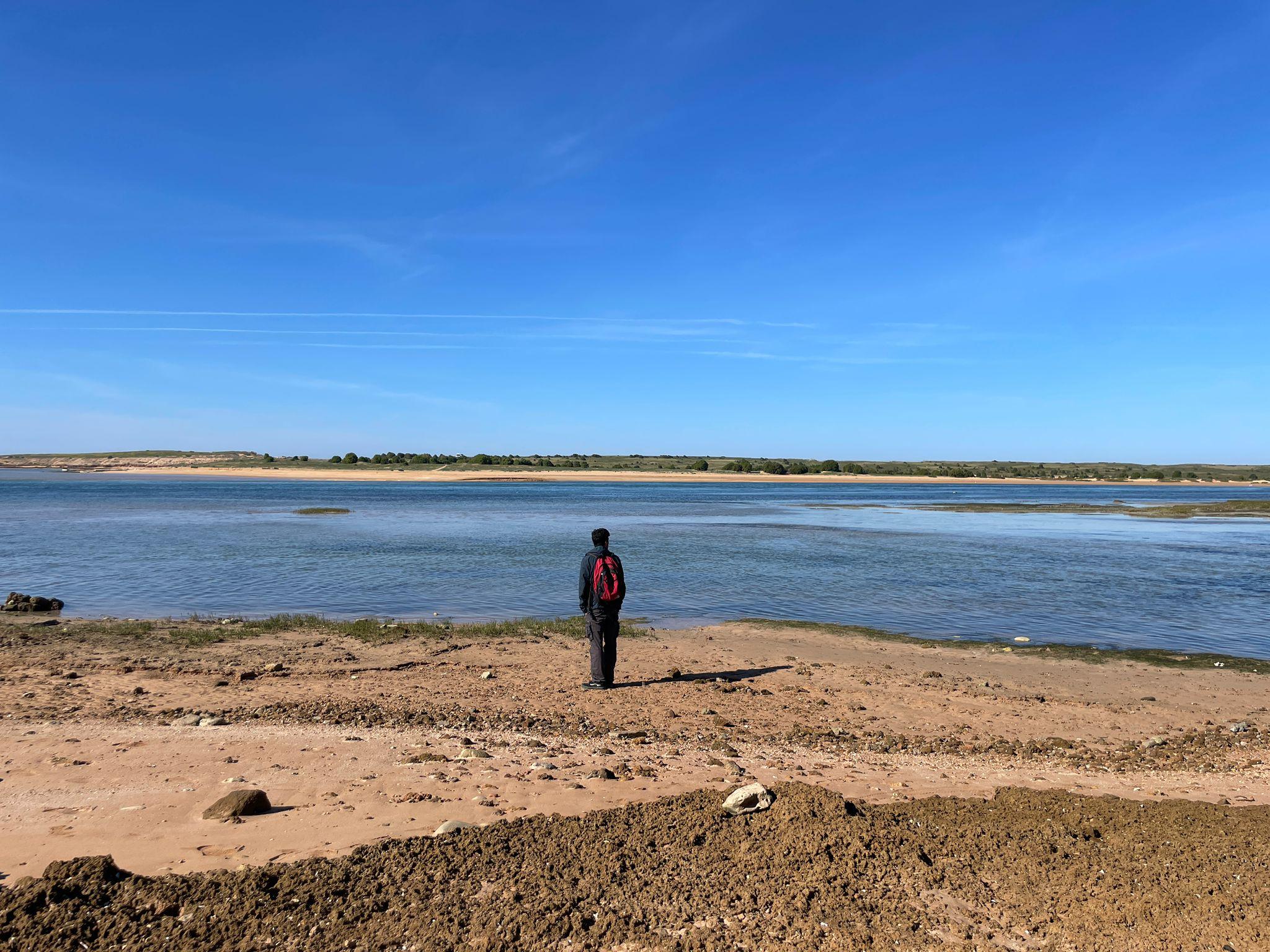 Ronald in a distance with the sea in a Morocco beach