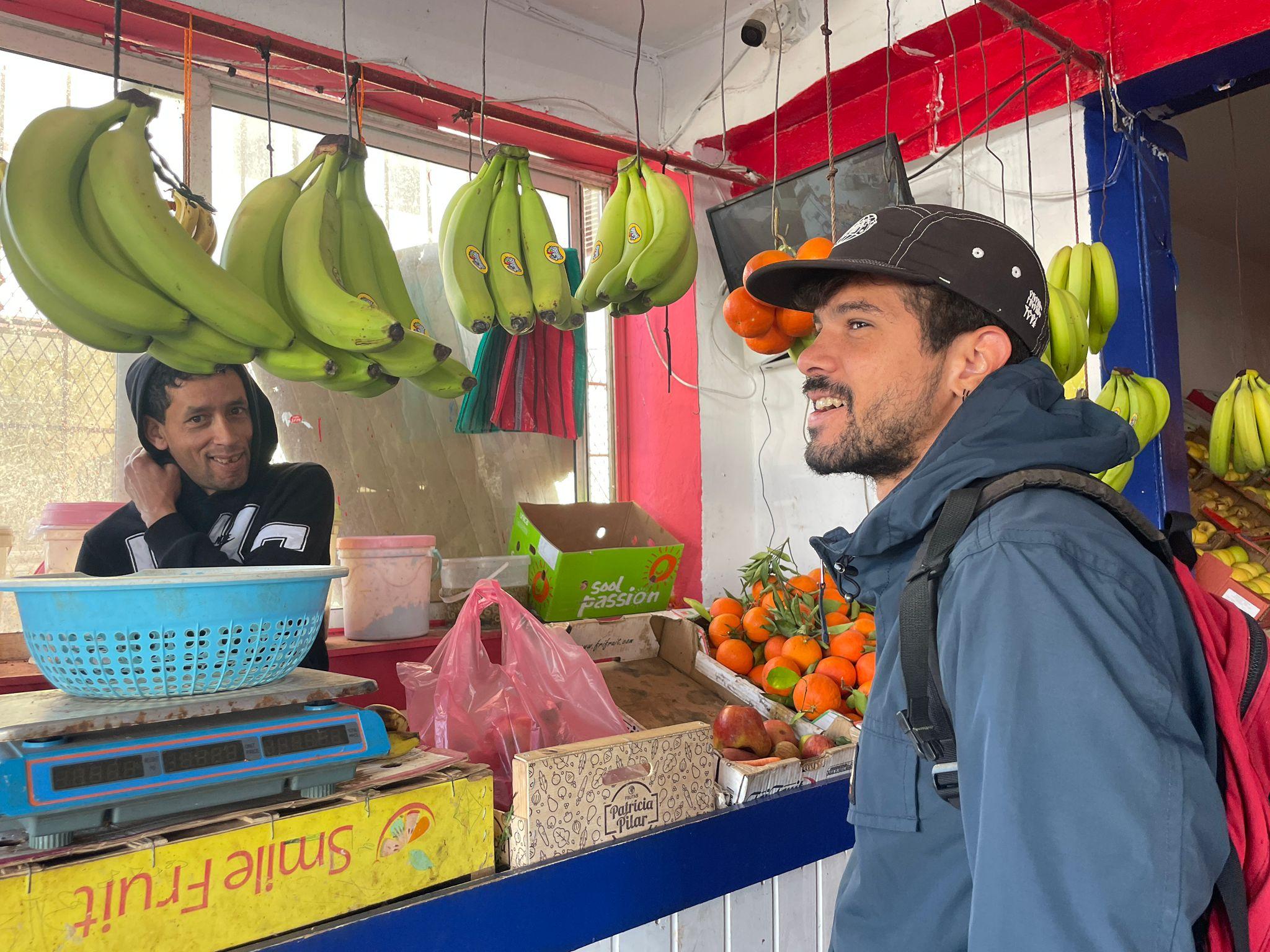 Ronald in Morocco talking with a local fruit seller in his regional language