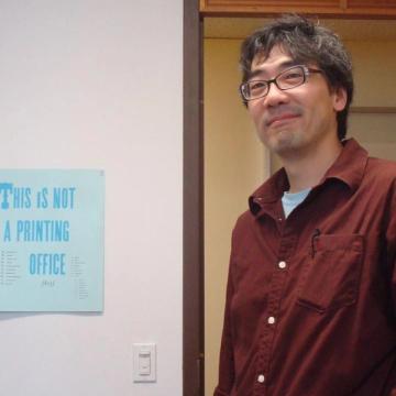 Artist Dan S. Wang standing in a door frame.