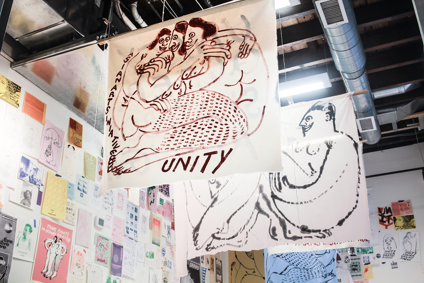 Banners of figure drawings that says UNITY