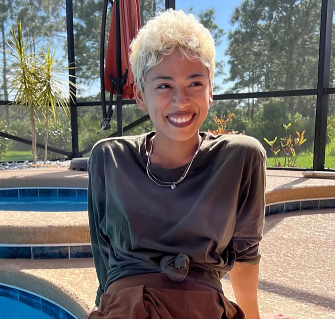 Artist Sonia Galiber sitting by a pool.