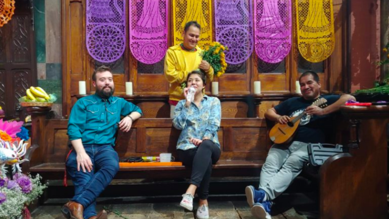 Three people sitting on a bench at Fleisher Art Memorial while a person is standing behind them holding flowers.