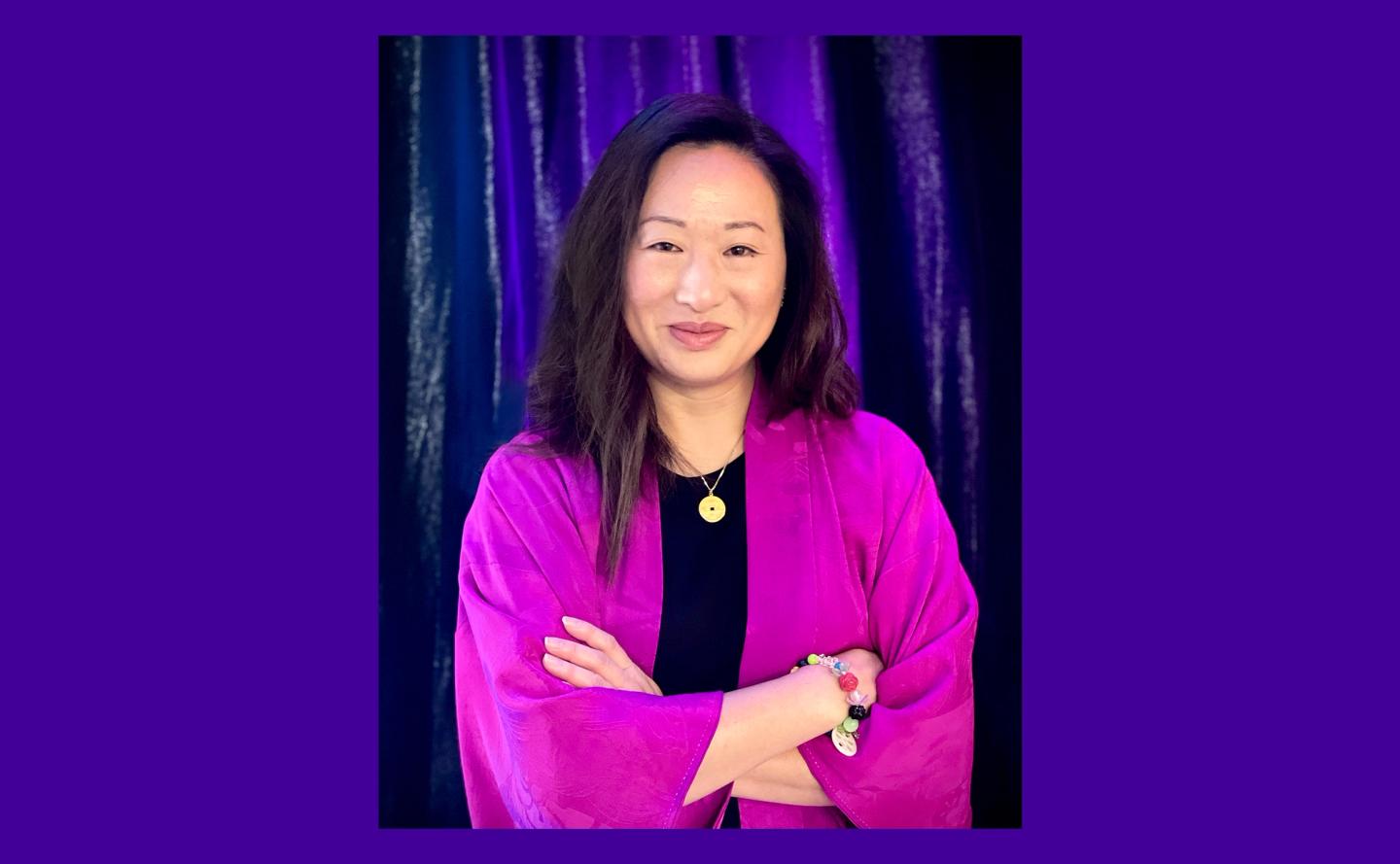 Portrait image of Executive Director Sonia Mak in pink outer wear against purple background