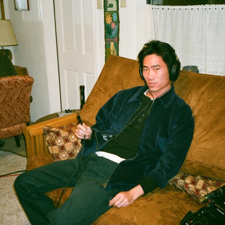 Headshot of Alex Shen slouching on a couch.