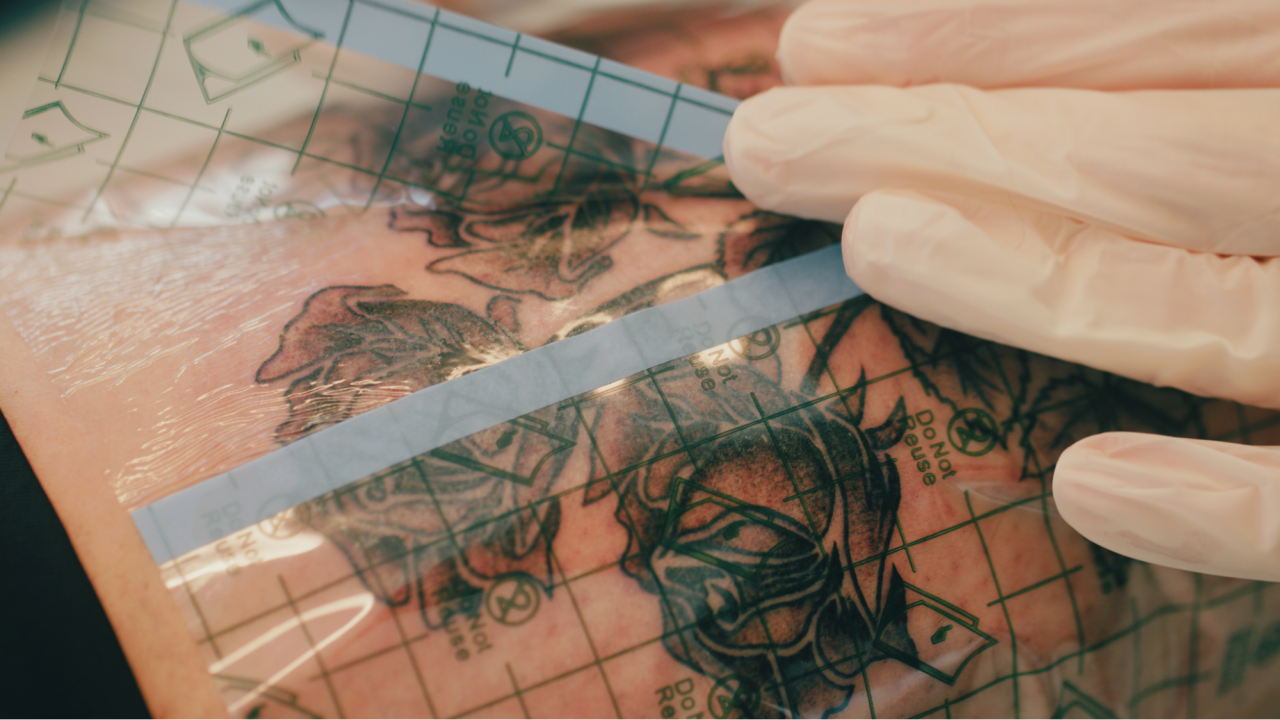 Saniderm being applied on a fresh roses tattoo.