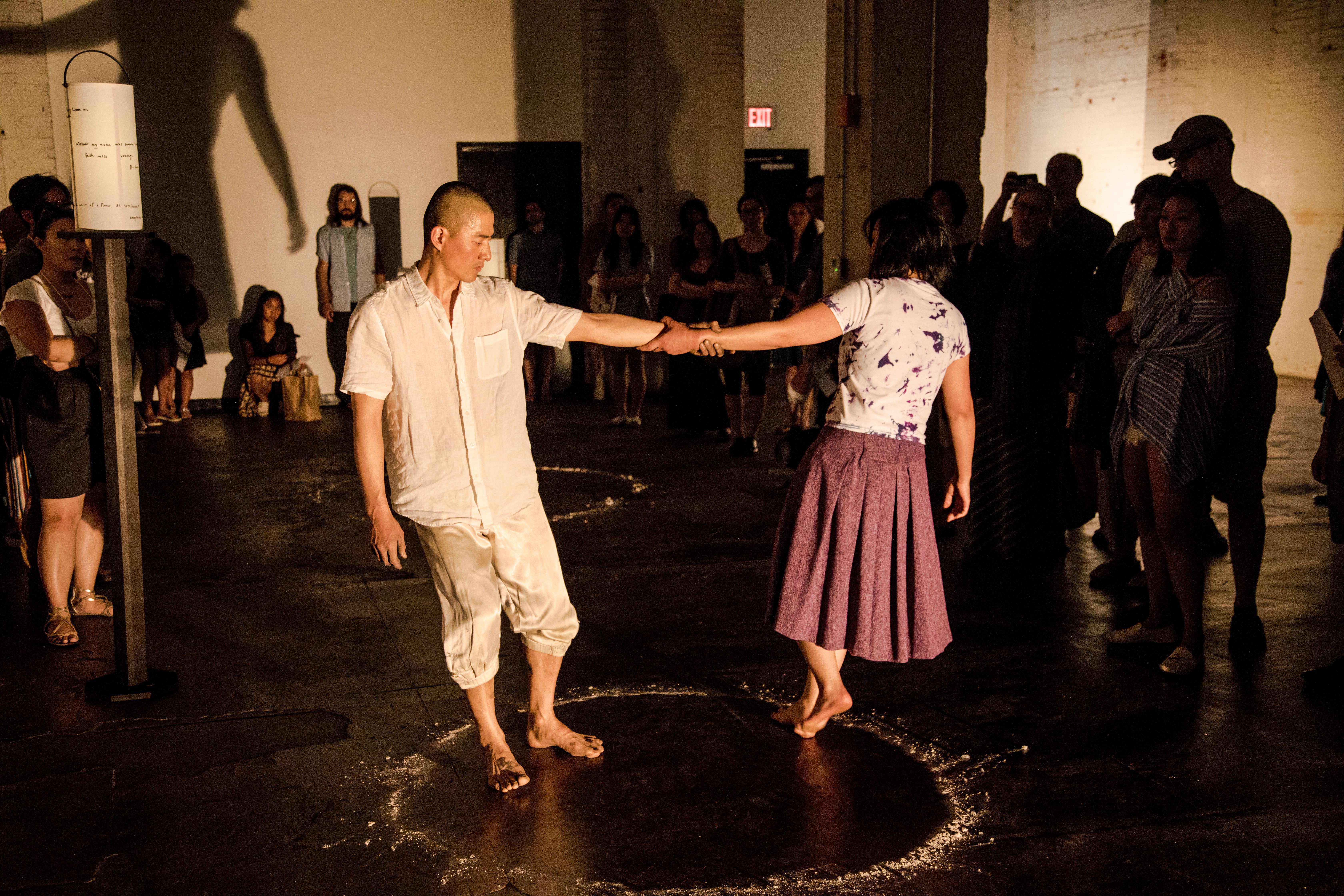 Julietee Sueyeun Lee and Jungwoong Kim performing Peace Light inside a circle made of dust.