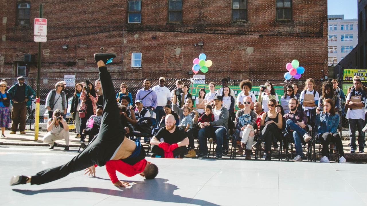 A dancer performing in front of a sit-down crowd.