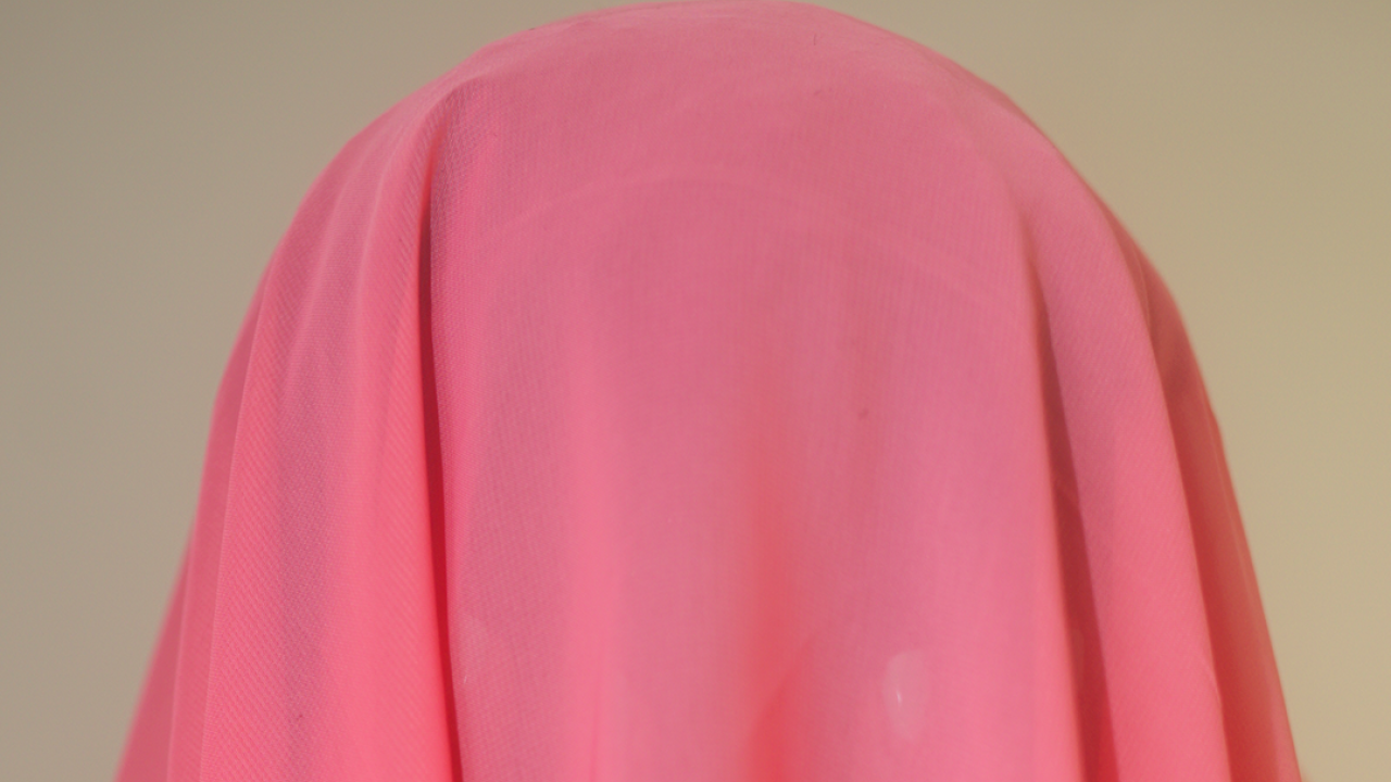 A person covered in pink fabric