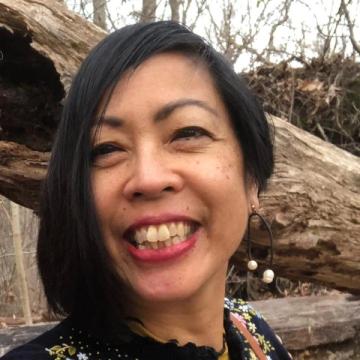 Headshot of Chanika Svetvilas in a forest with a huge log behind her.