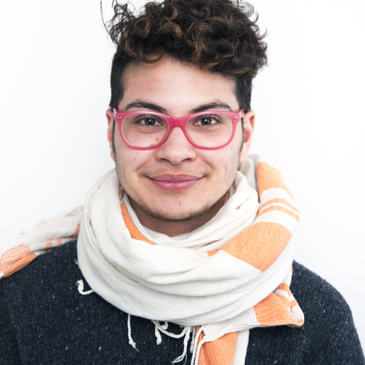 Headshot of Zavé Martohardjono wearing a white and orange scarf.