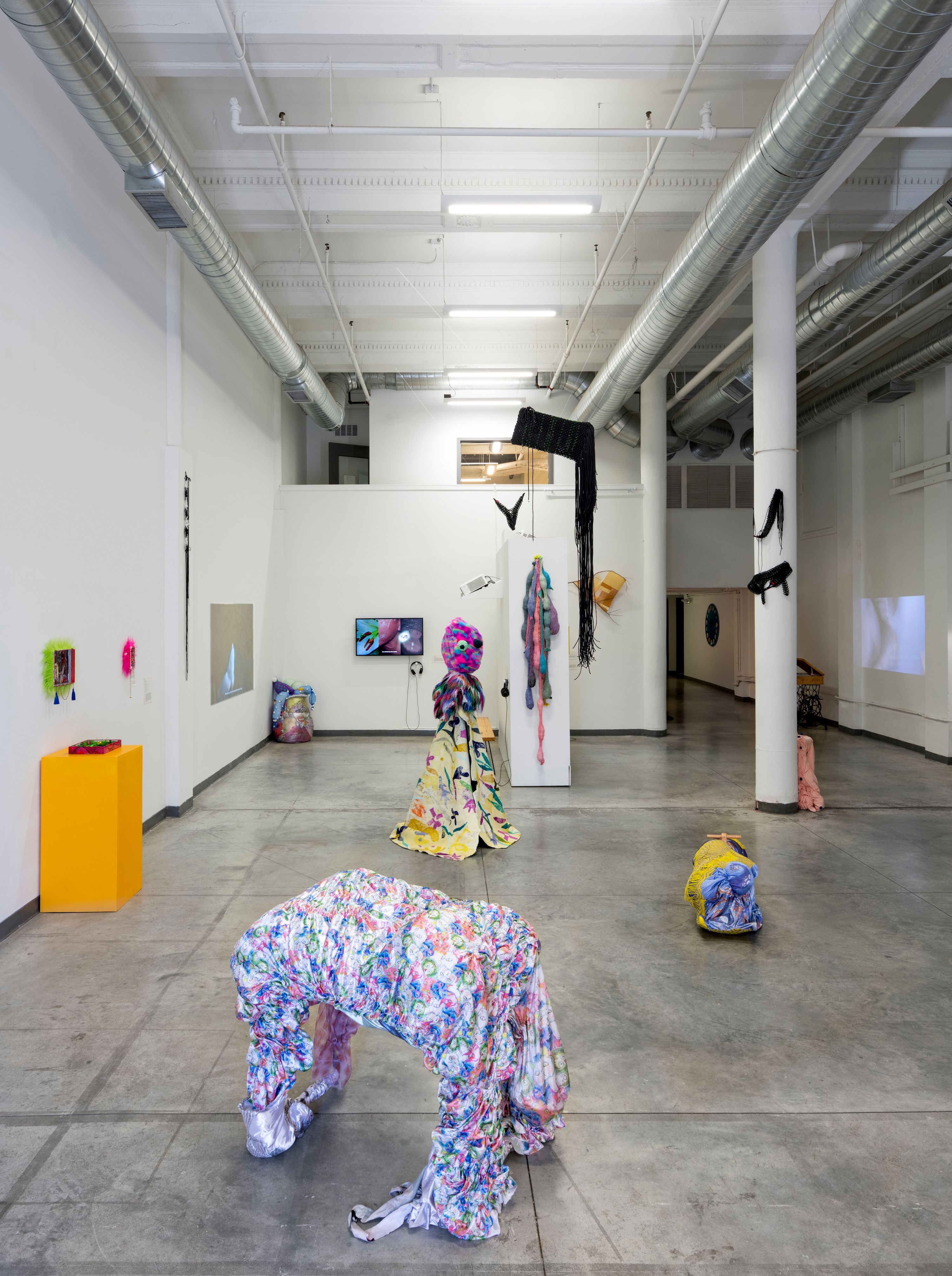 Installation of colorful fabric sculptures in a gallery space