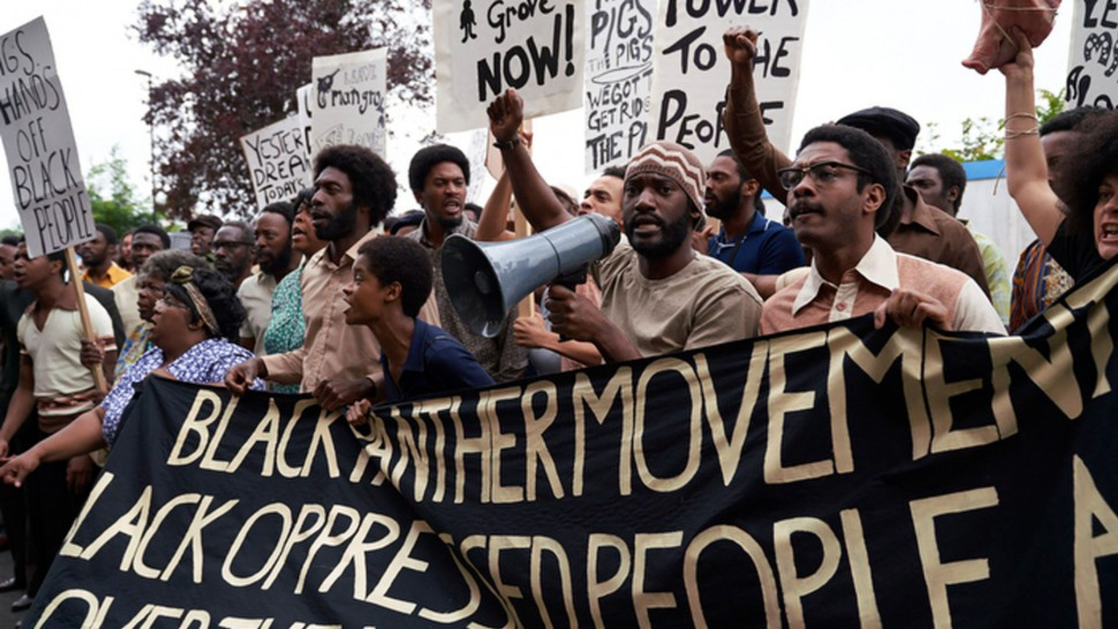 A group of black men and women holding placards and banners marching for 'black panther movemnent'. 


