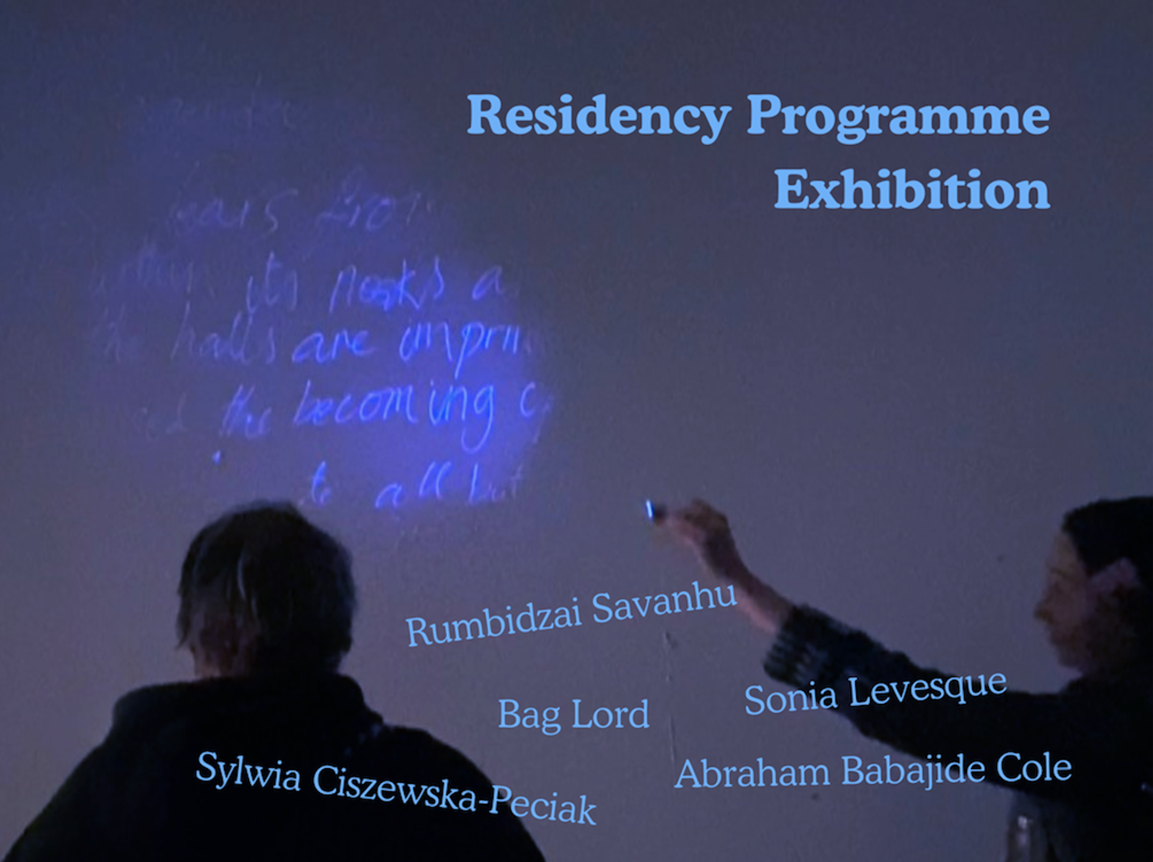 Two people looking at a white wall on which hidden writing is being exposed by UV light. Superimposed writing lists Artist in Residence's names. 