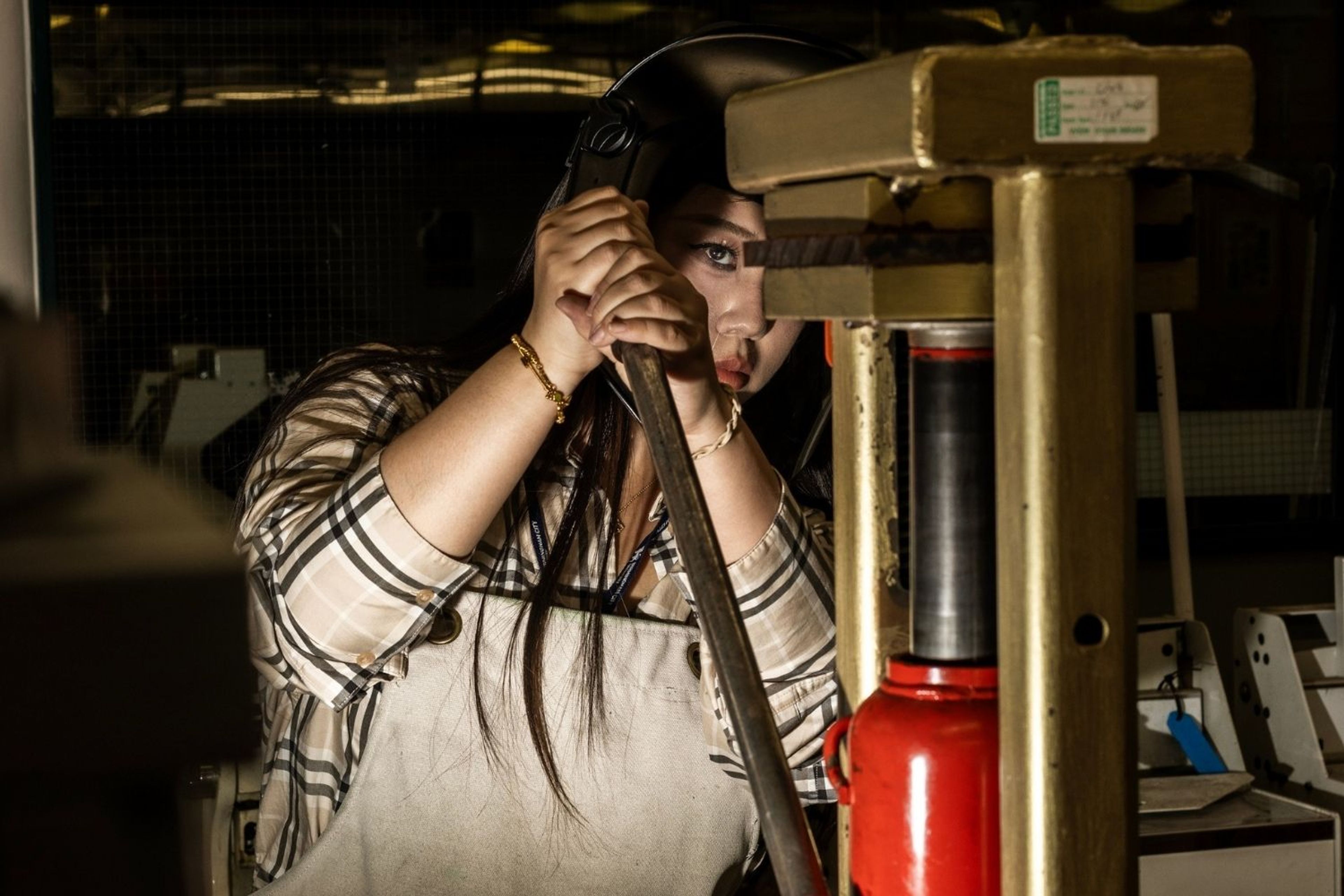 Image featuring a graduating student using a hydraulic press.