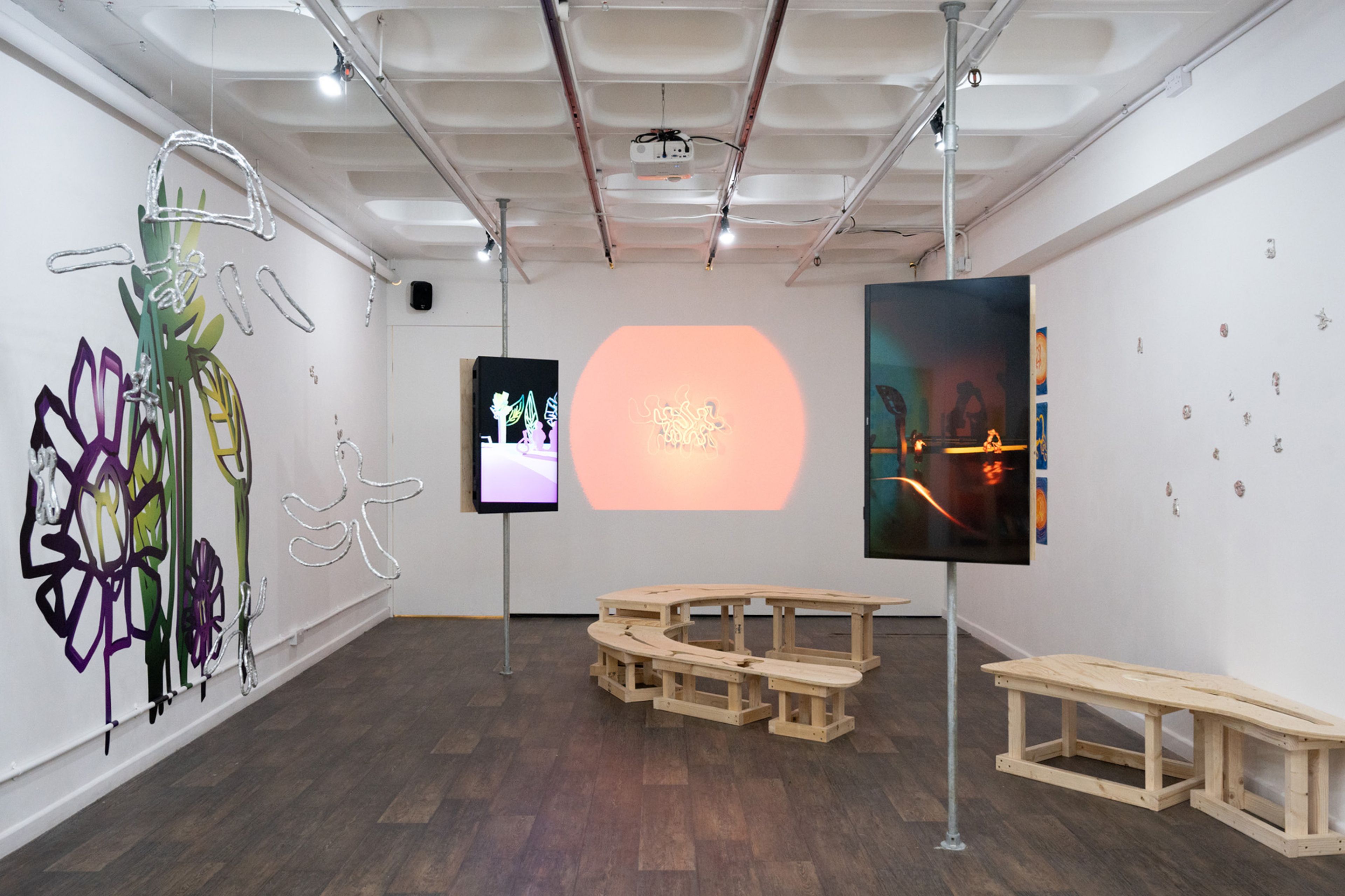 An image of a previous exhibition by Ama Dogbe at Modern Painters and new decorators in Loughborough. A white walled gallery space with artwork. 