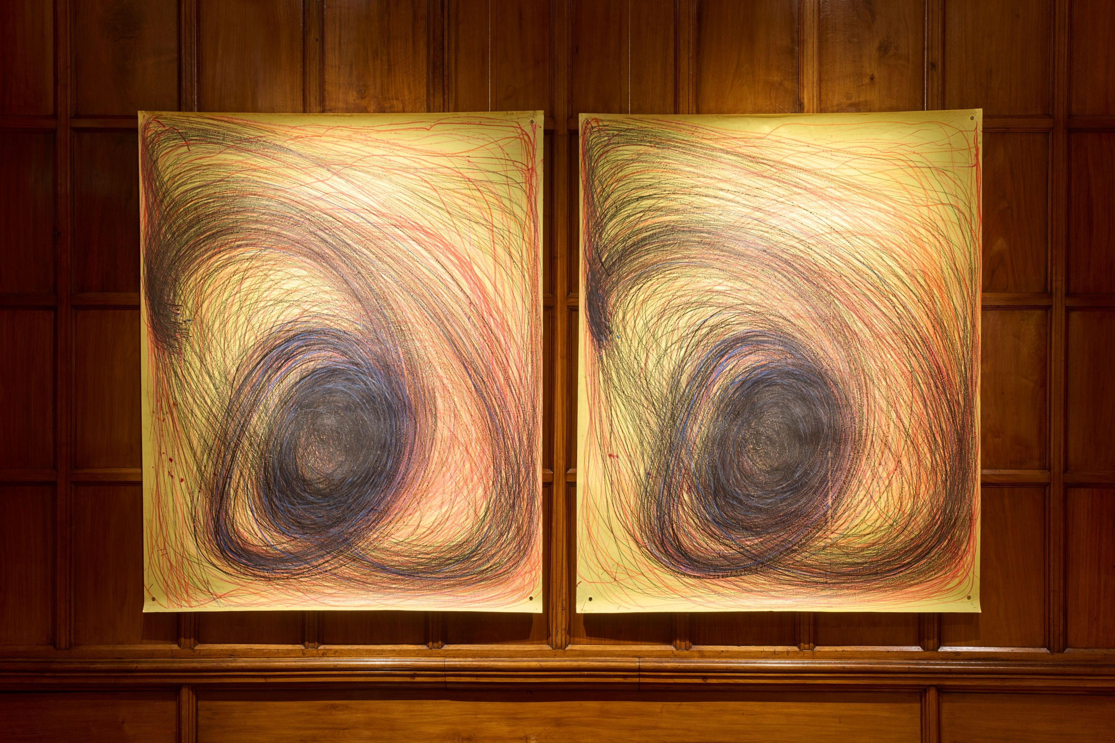 Two yellow pieces of paper pinned to a mahogany wood wall. The paper have swirling hand drawn lines on each of them, and look roughly the same. 