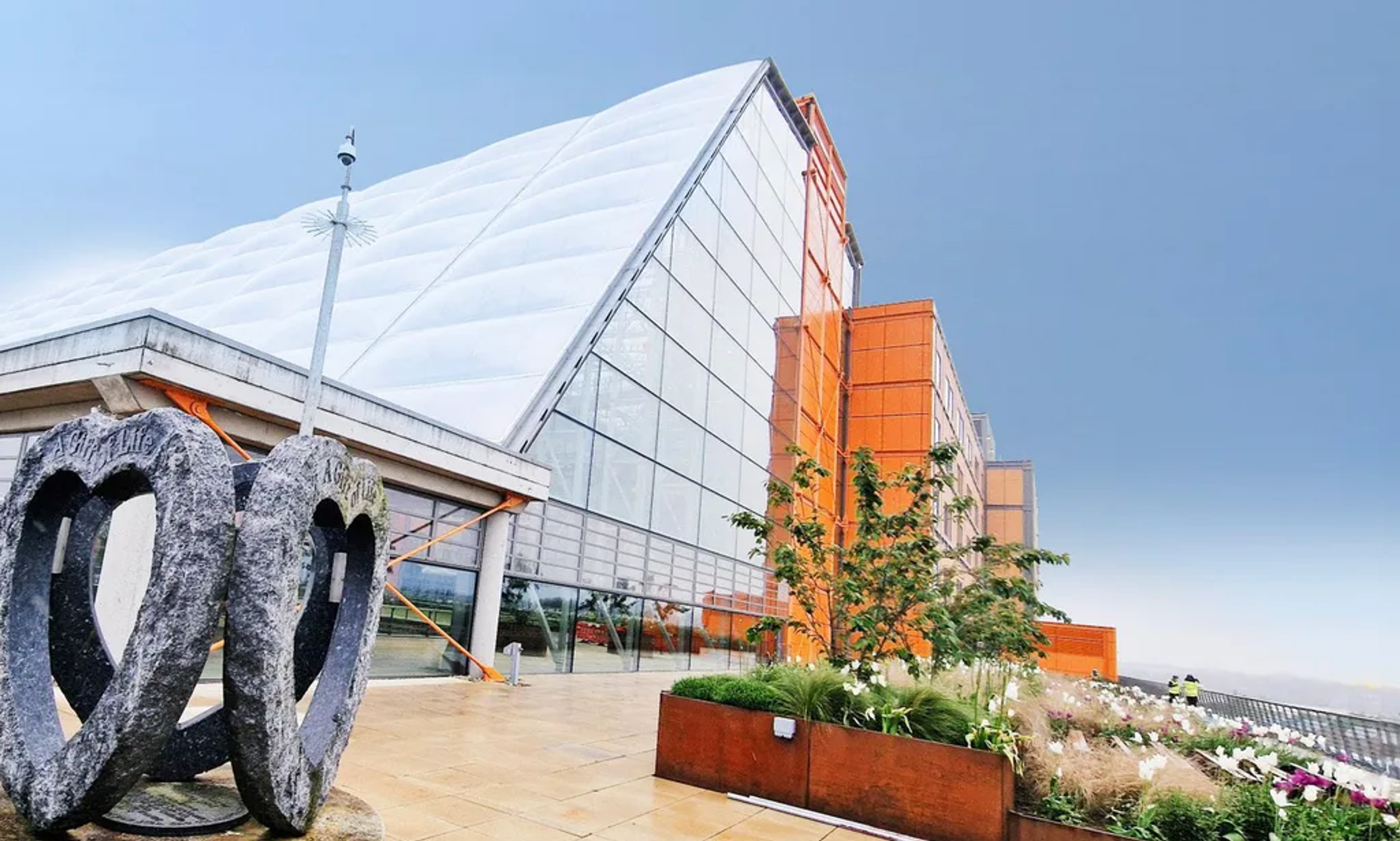 Midland Metropolitan University Hospital with a view from the terrace with heart shaped sculpture in the foreground and large planters.