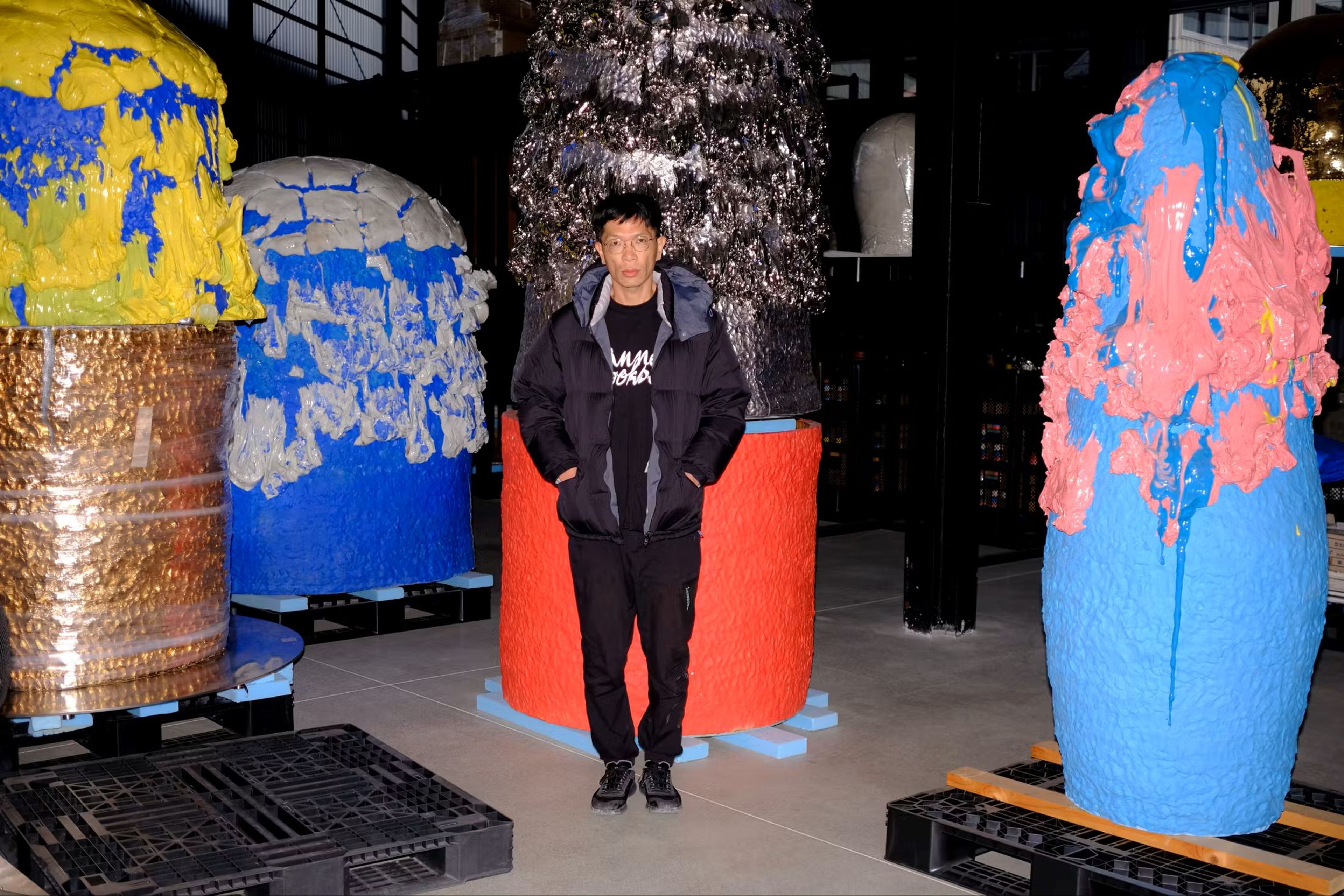 The artist, Takuro Kuwata, in front of his vibrantly coloured and oversized ceramic sculptures.