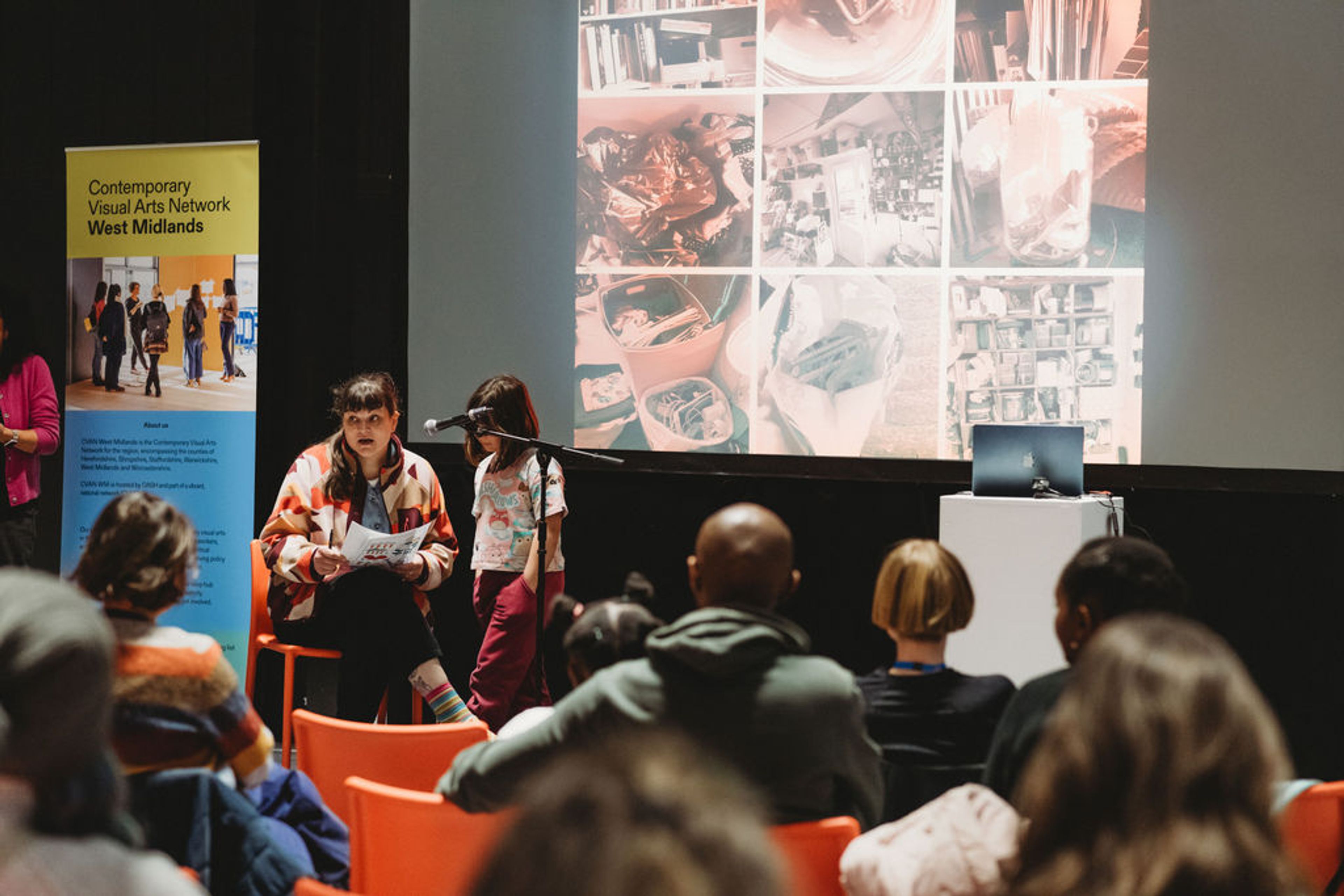 Two speakers on a stage presenting to an audience.