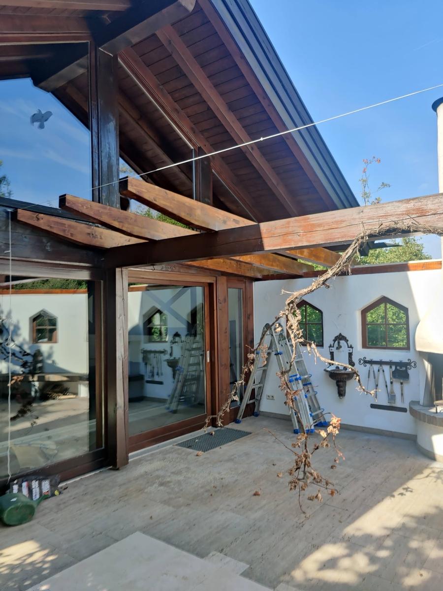 Holzveranda mit dunklem Fichtenholz und Stegplatten
